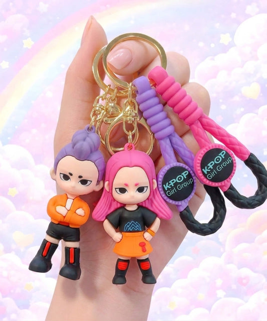 Kpop style demon hunter character keychains held in hand, cute girl group inspired bag charms with pastel rainbow background