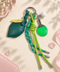 Lemon table tennis PU leather bag charm keychain with green rope cords on a soft neutral background