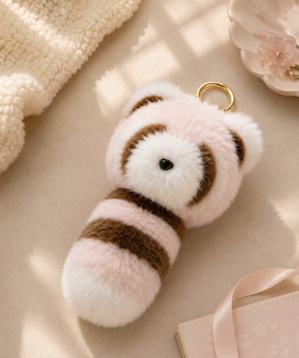 Pink and brown long tail raccoon plush keychain with soft striped tail and gold-tone keyring