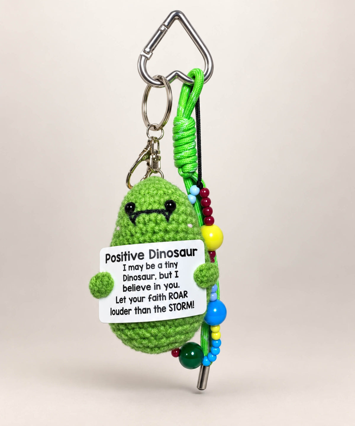 Green Positive Dinosaur crochet keychain holding an encouraging message card