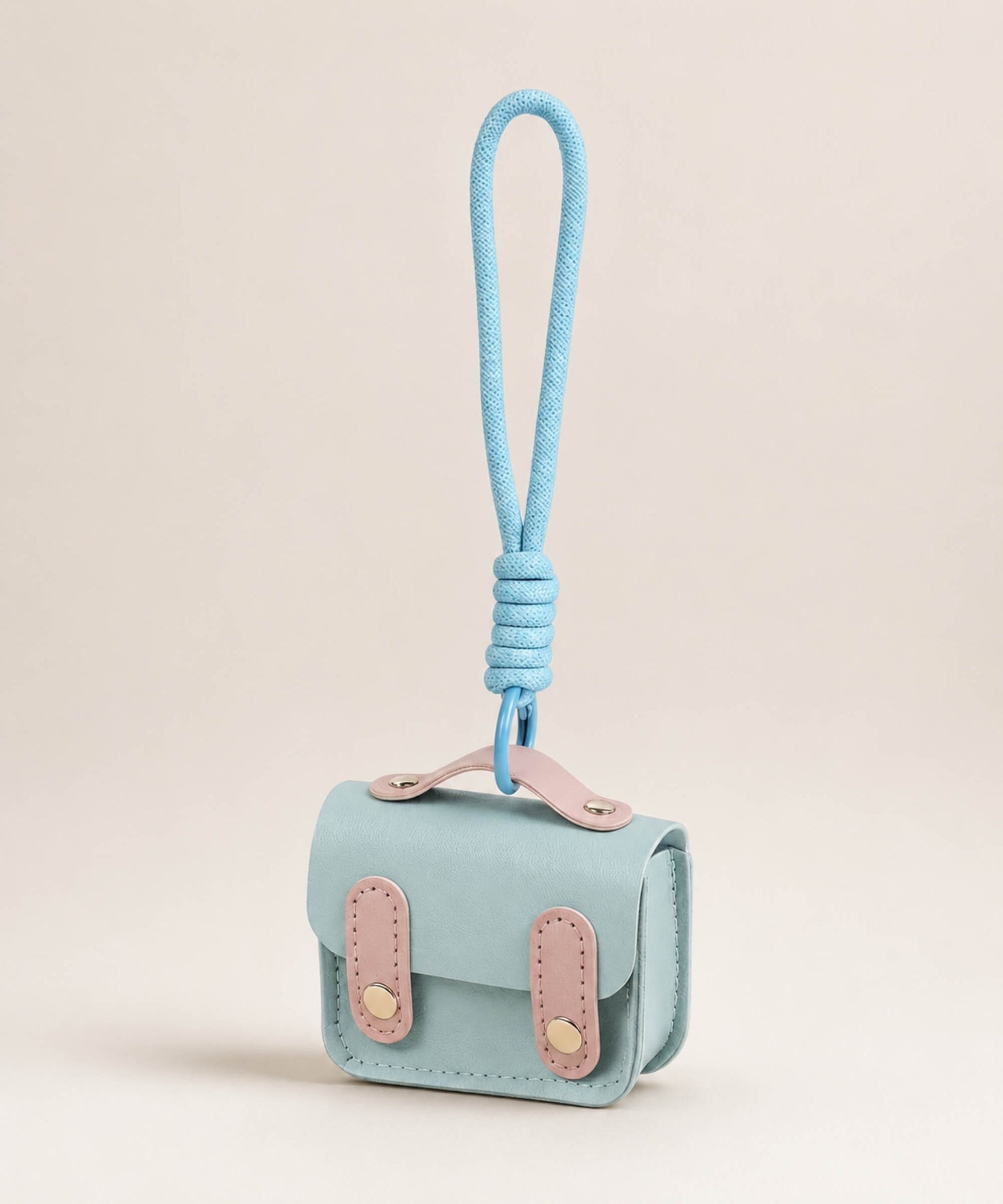 Blue mini PU leather earphone pouch keychain with wrist strap on a neutral background