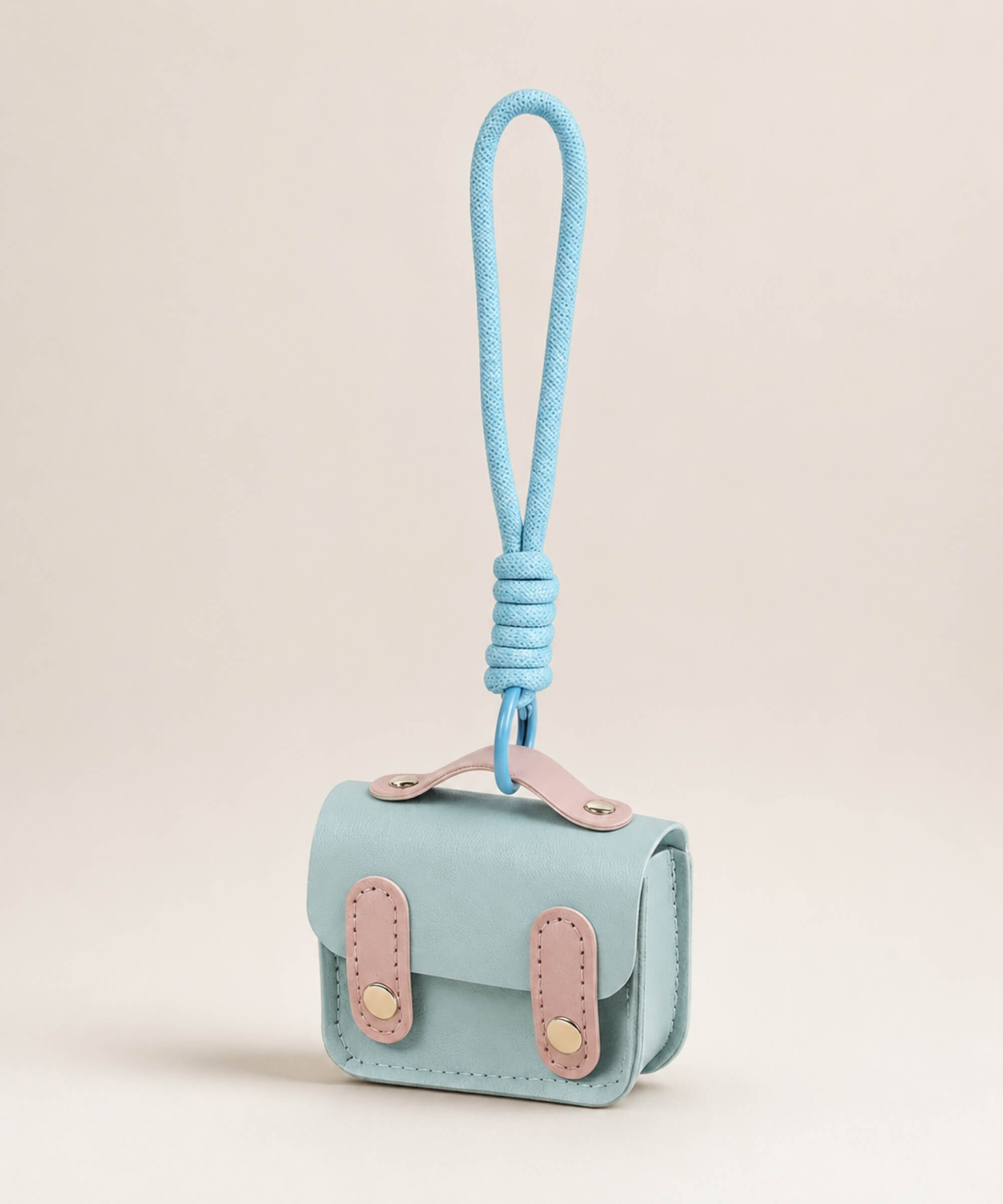 Blue mini PU leather earphone pouch keychain with wrist strap on a neutral background