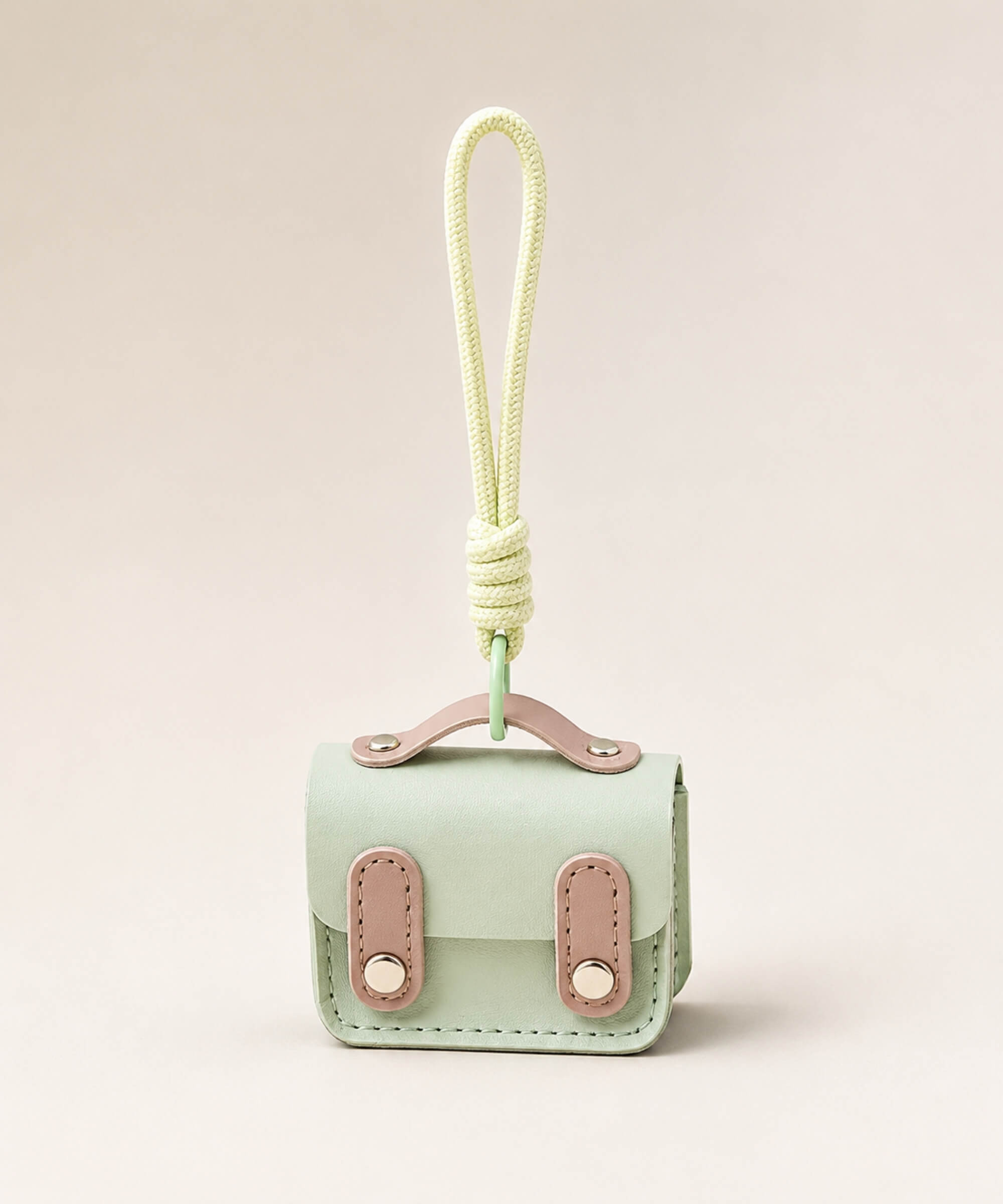 Mint mini PU leather earphone pouch keychain with wrist strap on a neutral background