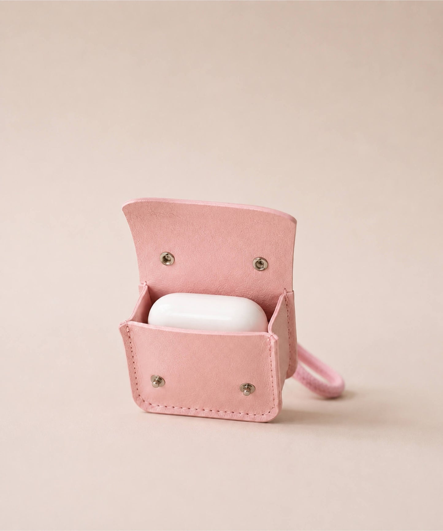 Open pink mini PU leather earphone pouch keychain showing a white earbud case inside