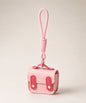 Pink mini PU leather earphone pouch keychain with wrist strap on a neutral background