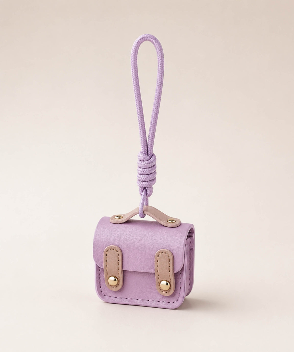 Purple mini PU leather earphone pouch keychain with wrist strap on a neutral background
