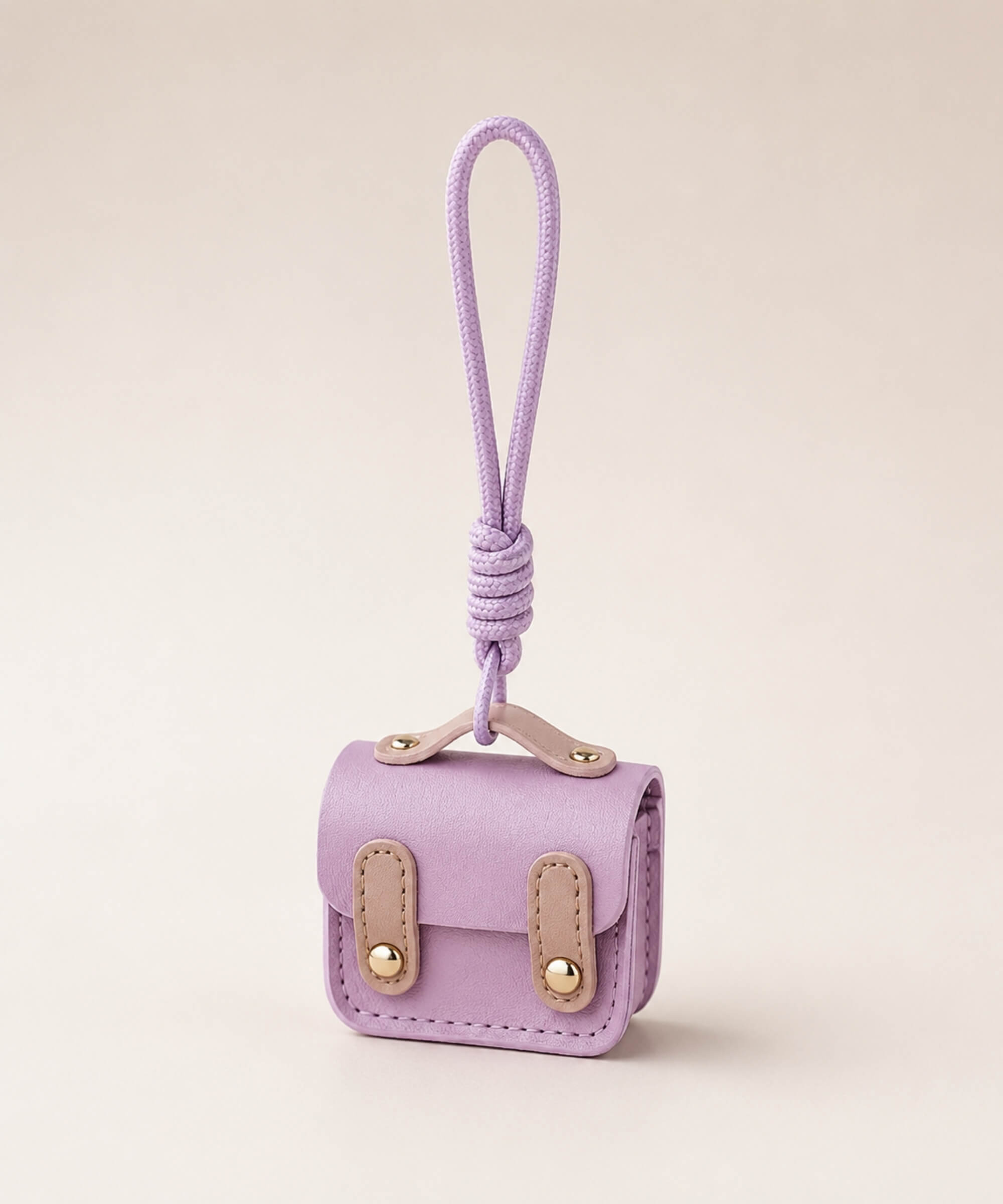 Purple mini PU leather earphone pouch keychain with wrist strap on a neutral background