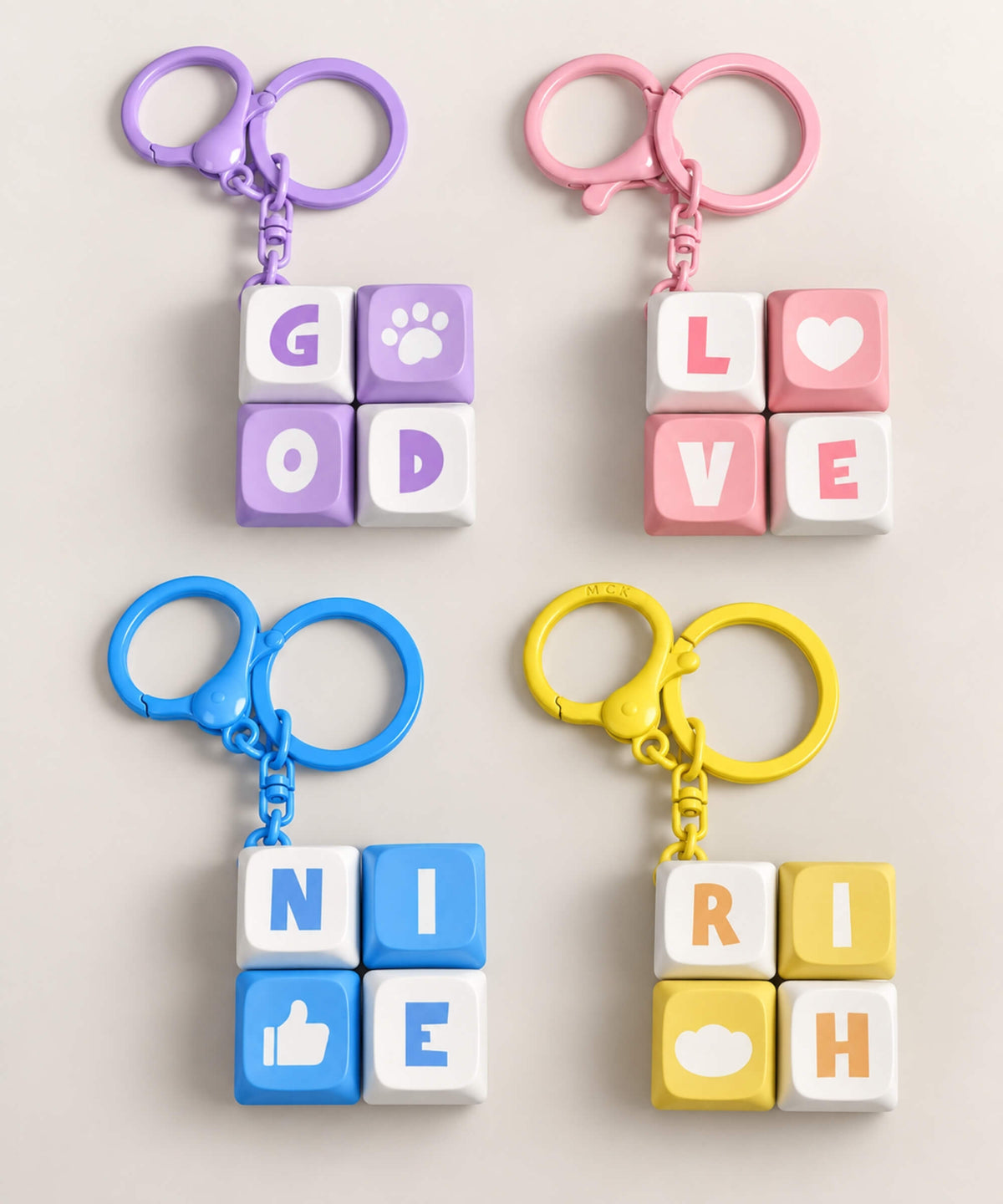 Four mini keyboard fidget keychains in purple pink blue and yellow designs