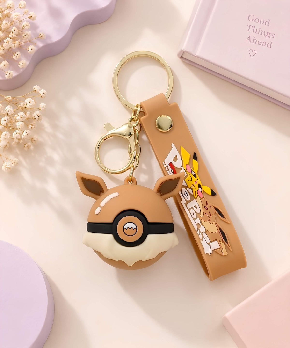Brown Poke Ball-inspired strap keychain with cute animal ear design, matching wrist strap and gold-tone hardware