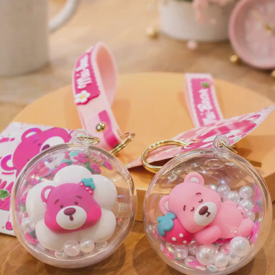Strawberry bear shaker keychain with floating beads displayed in lifestyle setting