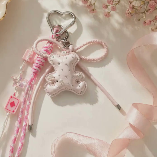 Pink bear PU leather bag charm keychain with a sparkle charm shown in a lifestyle video with a slow zoom-in.