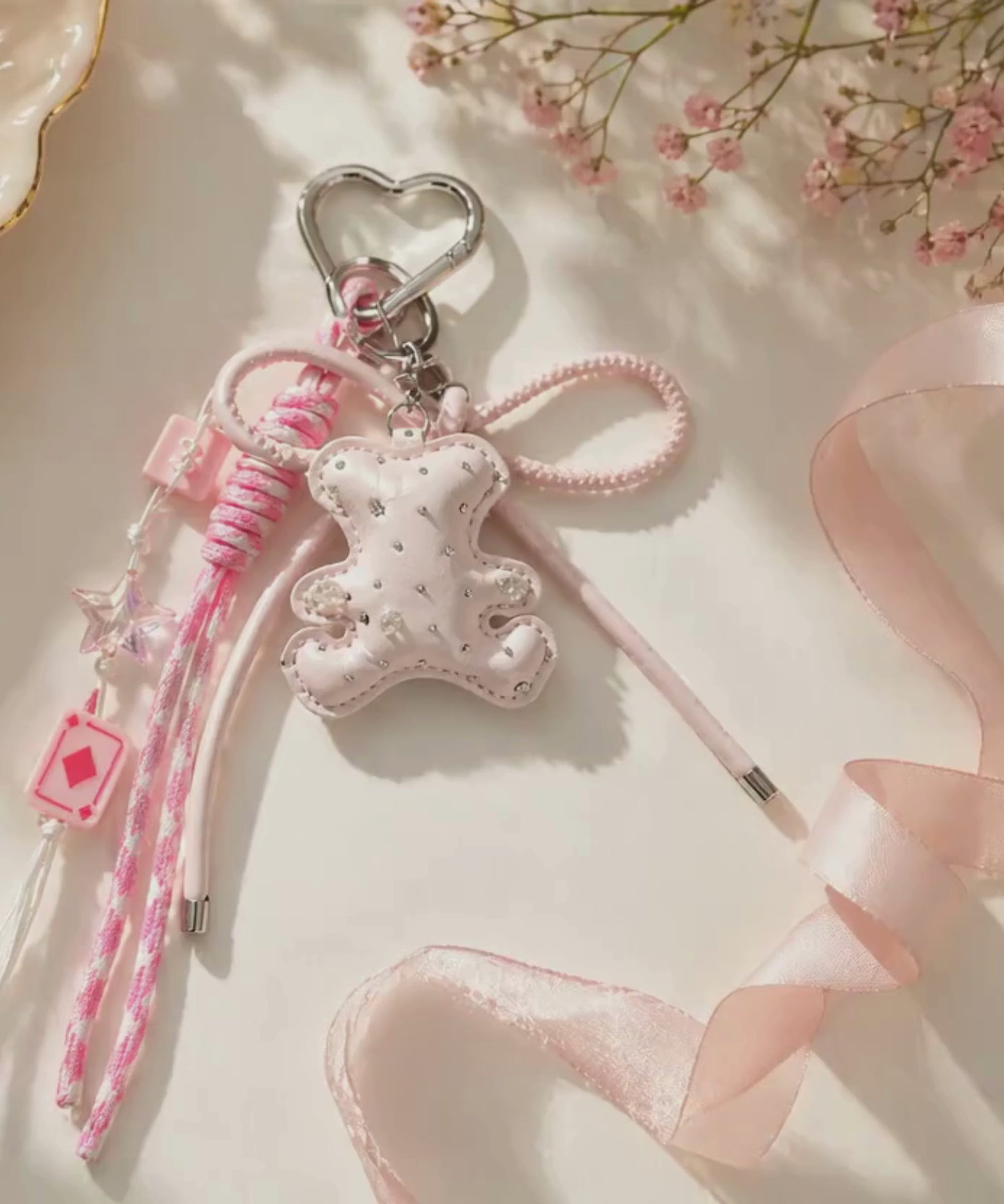 Pink bear PU leather bag charm keychain with a sparkle charm shown in a lifestyle video with a slow zoom-in.