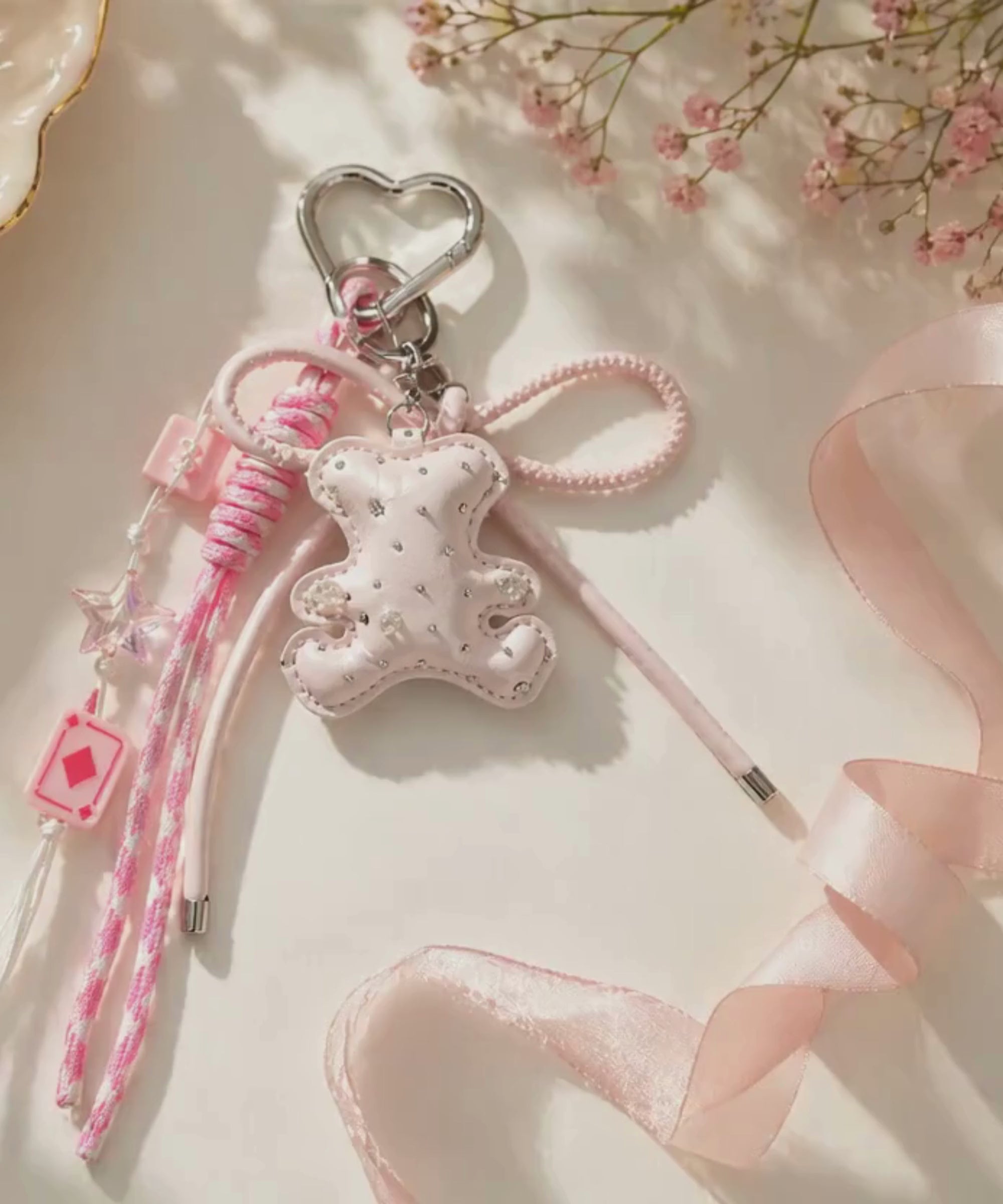 Pink bear PU leather bag charm keychain with a sparkle charm shown in a lifestyle video with a slow zoom-in.