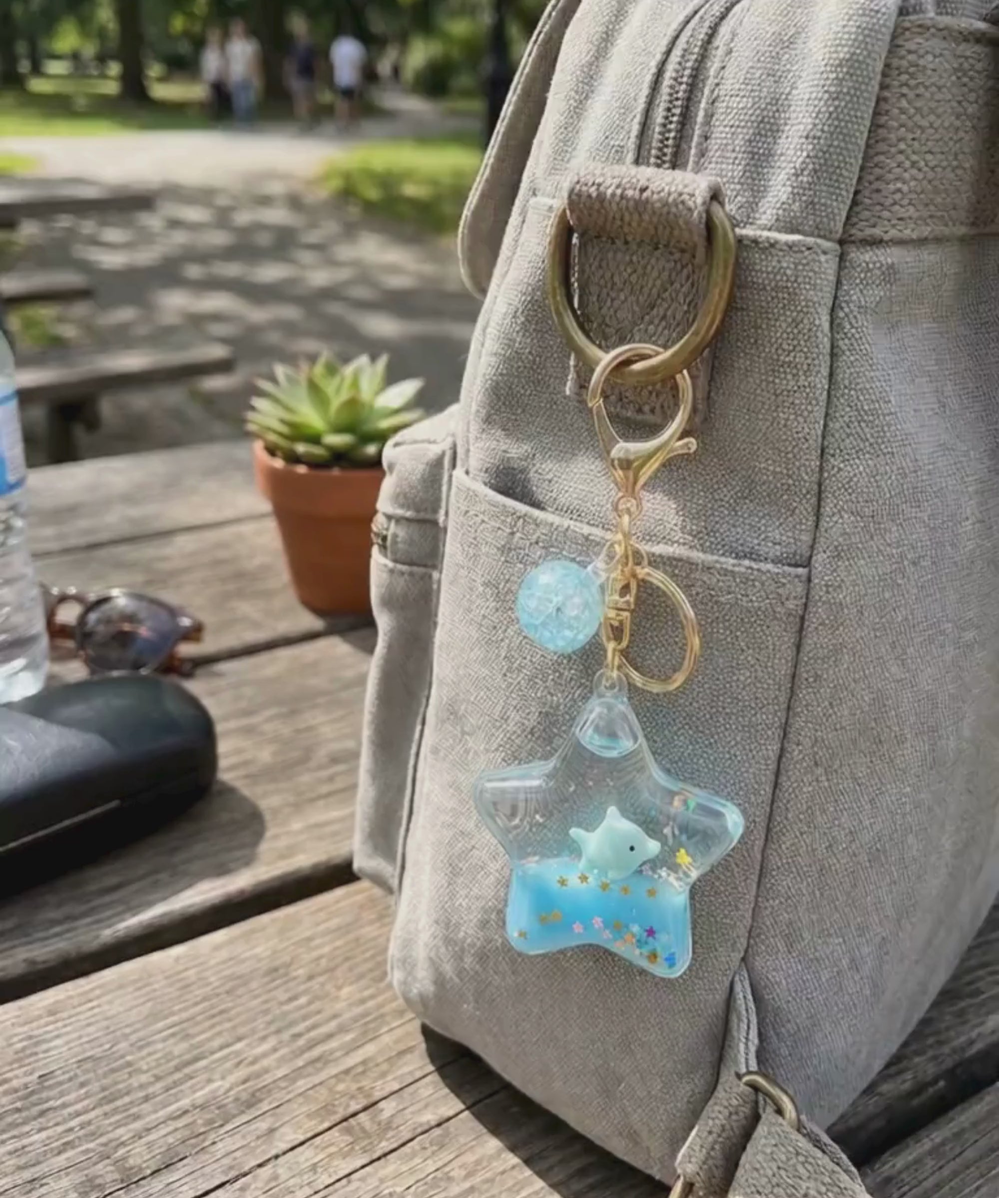 Star liquid glitter keychain blue bag charm hanging on backpack outdoor lifestyle scene