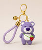 Purple strawberry bear resin keychain with braided wrist strap and gold keyring