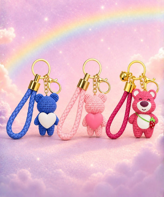 Resin keychains featuring knitted-look heart bears and strawberry bear bag charms on a dreamy rainbow background