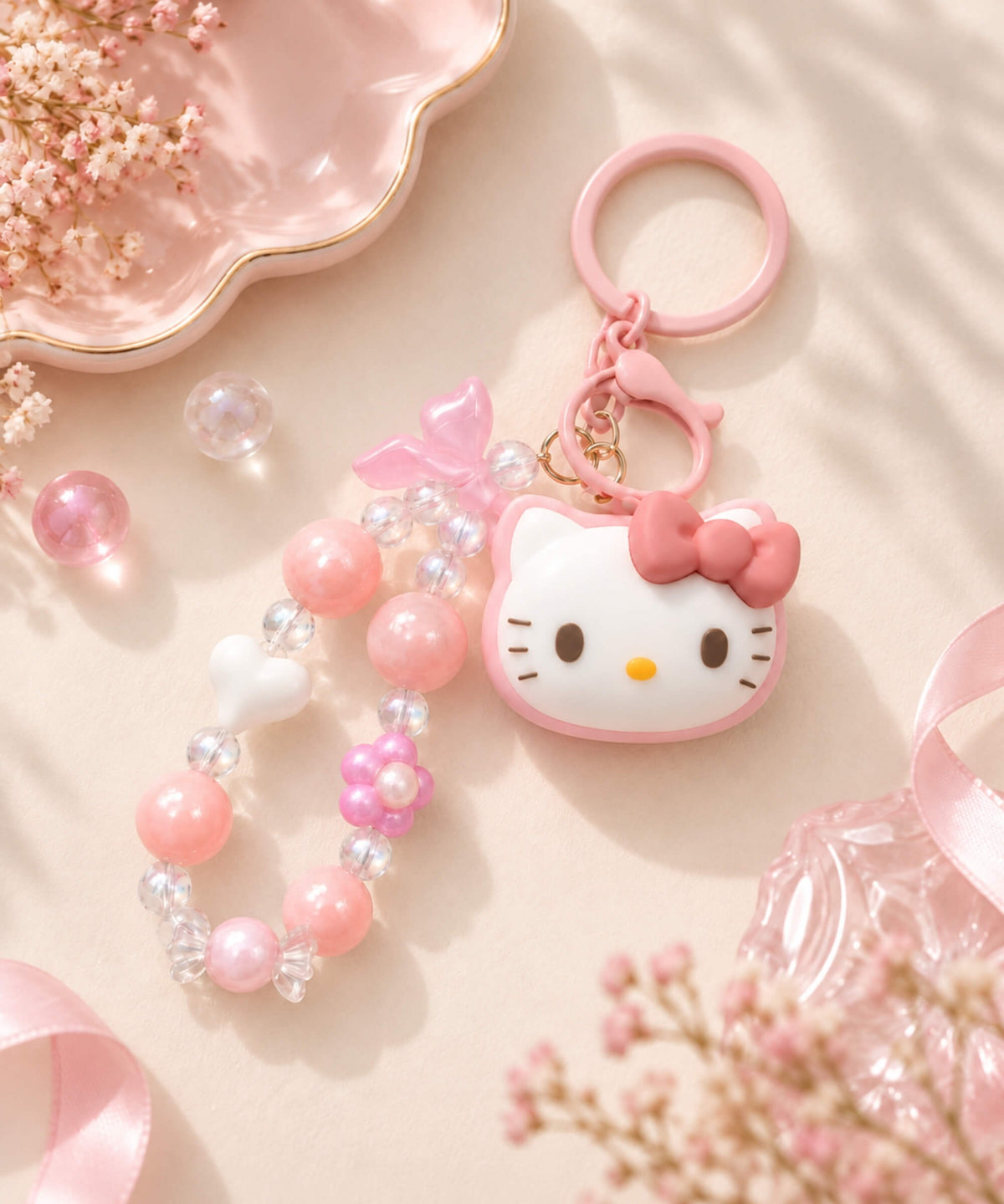 Hello Kitty beaded keychain with pink and clear beads, heart and flower details, character charm and pink keyring