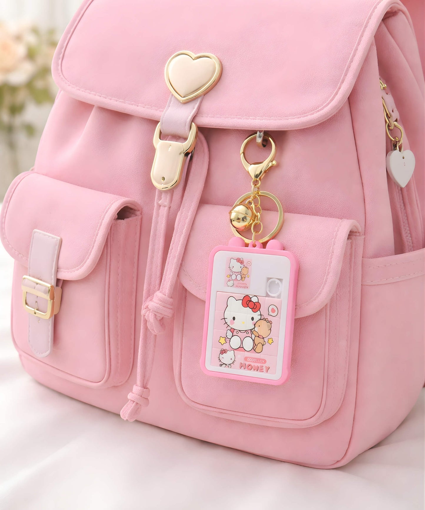 Hello Kitty puzzle keychain hanging on pink backpack cute Sanrio bag charm lifestyle use