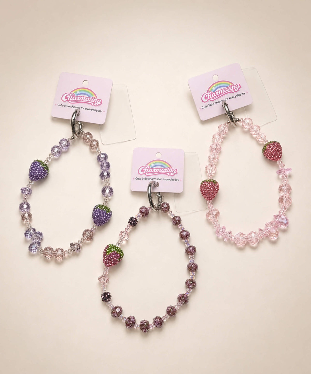 Three strawberry beaded phone charms with crystal-style beads in pink, lilac and mauve designs