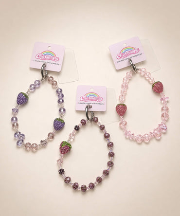 Three strawberry beaded phone charms with crystal-style beads in pink, lilac and mauve designs