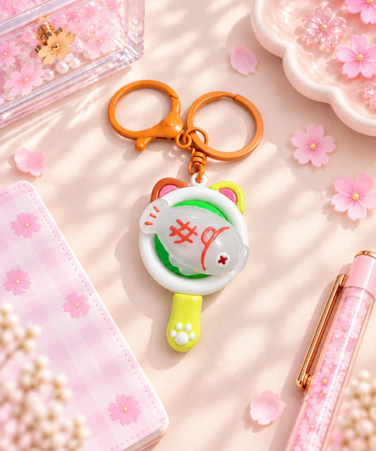 UV colour-changing Fish spinner keychain styled on a pink desk