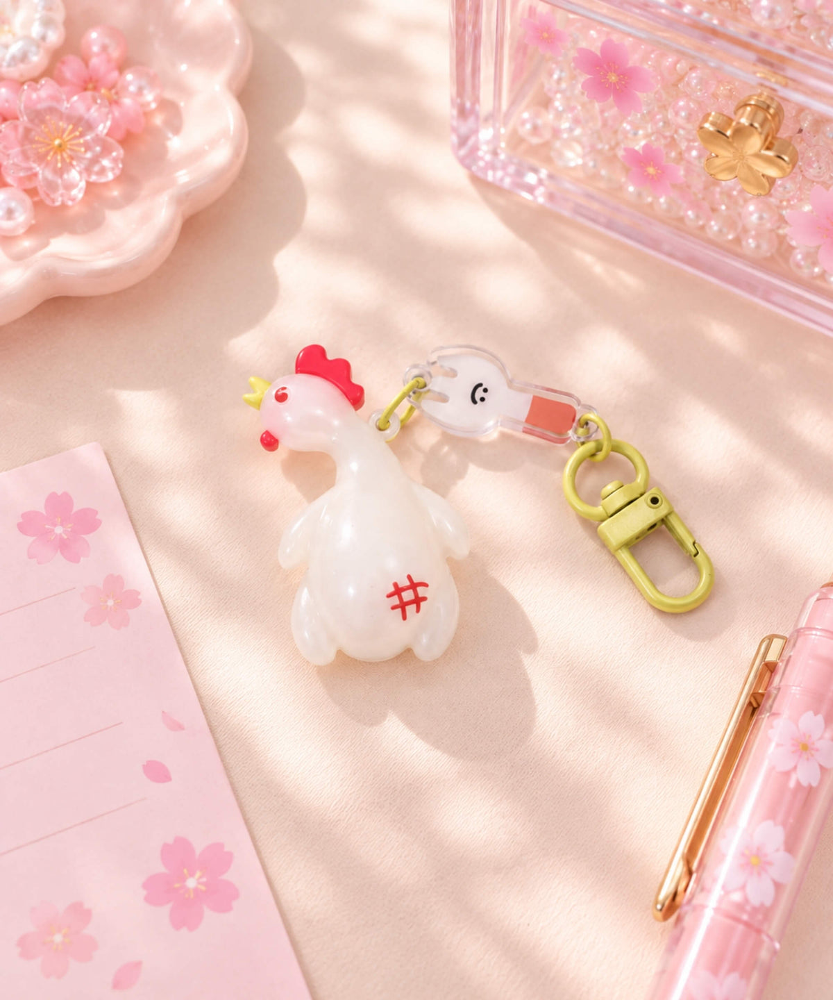 UV colour-changing Chicken keychain styled on a pink desk