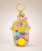 Yellow dessert water ring game keychain with button and gold bell